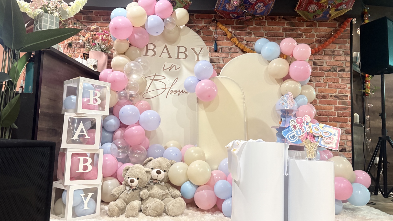 Pink blue and cream balloon display with Baby in Bloom backdrop at Aura Indian Cuisine